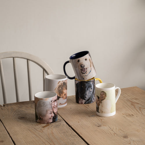 A selection of personalised photo mugs with family photos on the table